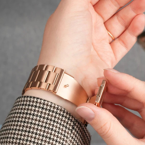 Gliederarmband aus Edelstahl in Roségold für Apple Watch – Nahaufnahme des Verschlusses am Handgelenk.