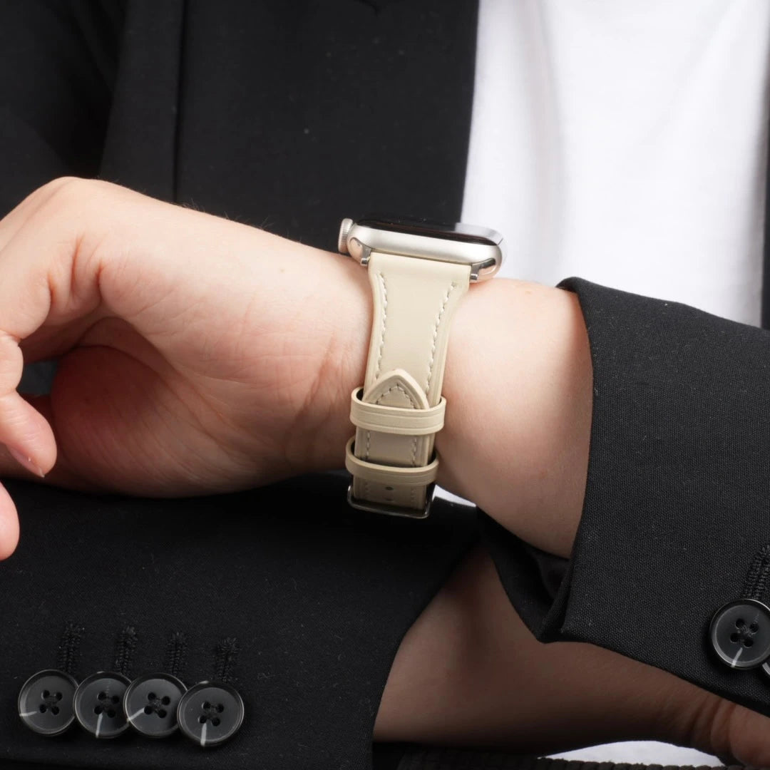 Apple Watch mit beigem Breband Lederarmband am Handgelenk einer Person mit schwarzem Blazer. #farbe_beige