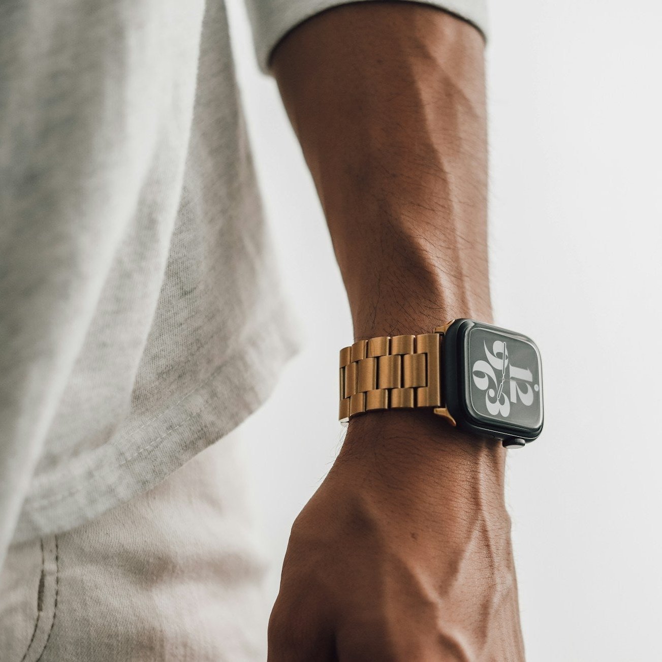 Apple Watch mit goldenem Metallarmband am Handgelenk einer Person 3